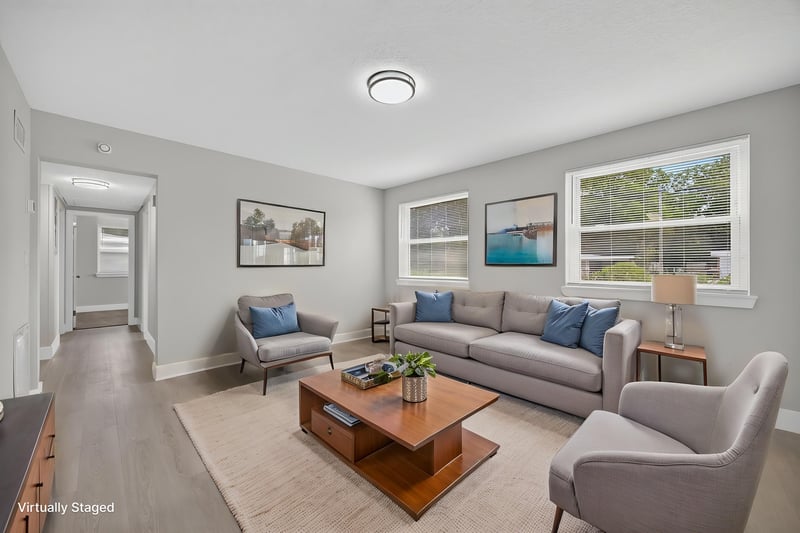 Living room with staged sofas and wood-look flooring at 6238 Randia Dr, Jacksonville, FL 32210