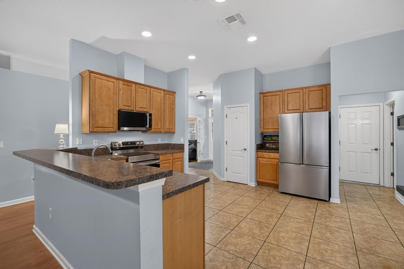 Kitchen with wood cabinets and tile backsplash at 3112 Silverado Cir, Green Cove Springs, FL 32043