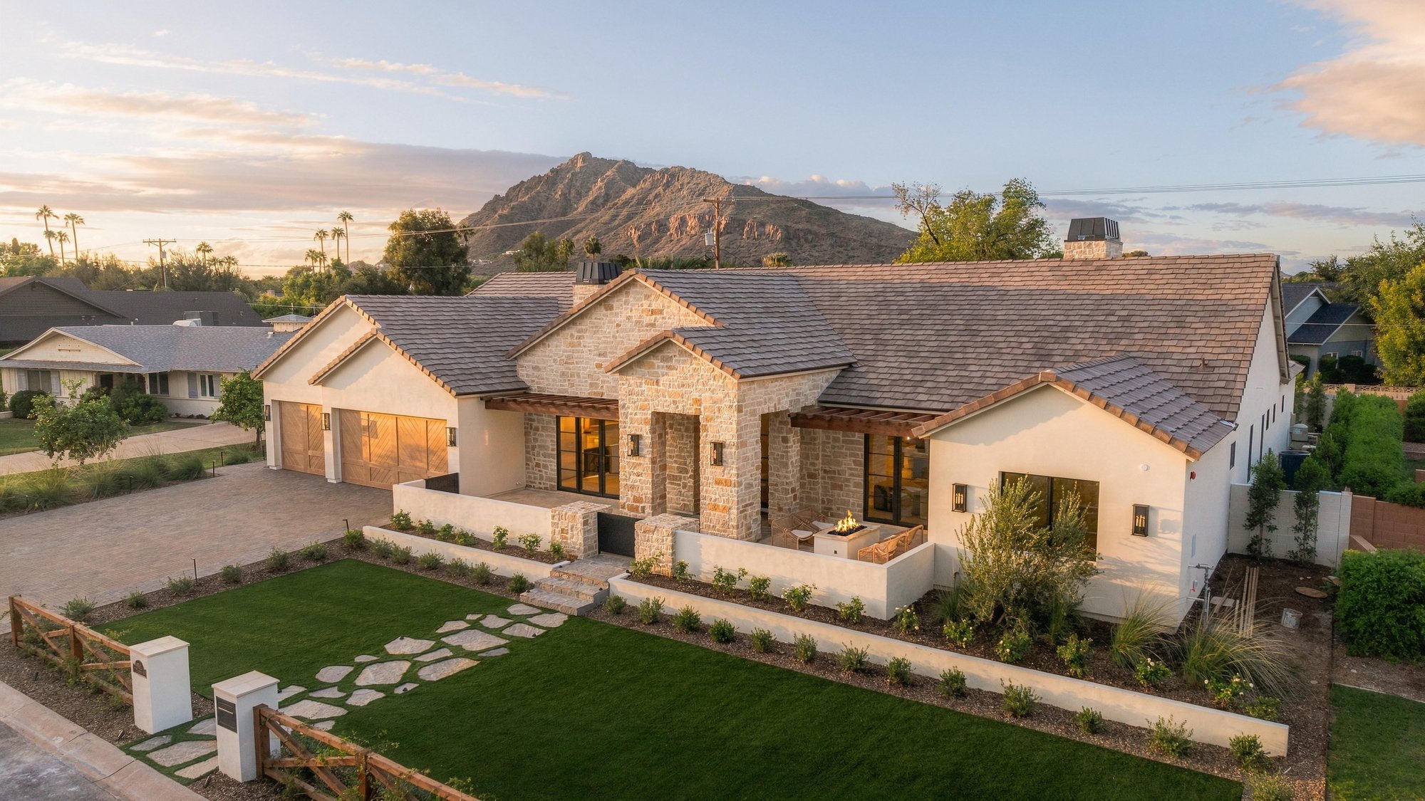Aerial of a stone home with Camelback Mountain behind it