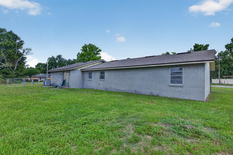 Side exterior view with brick wall and lawn at 1143 Tumbleweed Dr, Orange Park, FL 32065