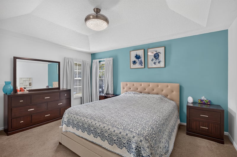 Primary bedroom with teal accent wall and wood furniture at 12825 Kelsey Island Dr, Jacksonville, FL 32224