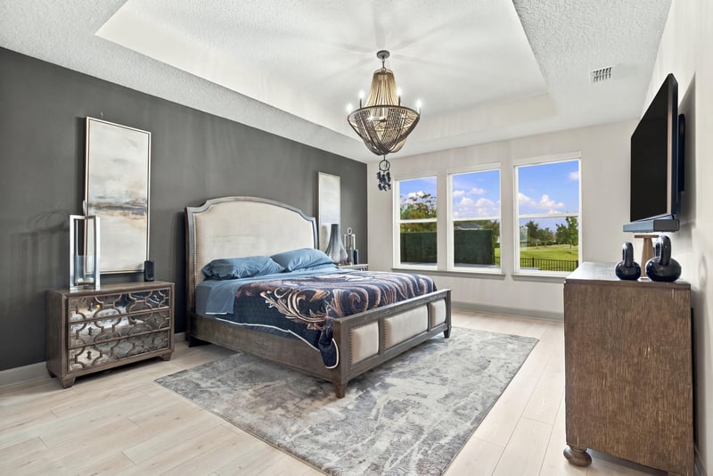 Primary bedroom with dark accent wall and chandelier at 3921 Spyglass Hill Ln