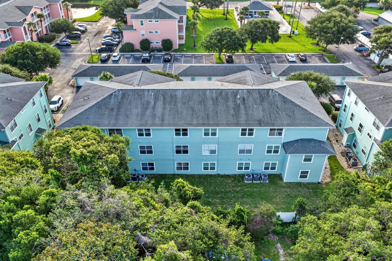 Aerial view of the condo building rooftop among trees at 206 16th St, St. Augustine, FL 32080