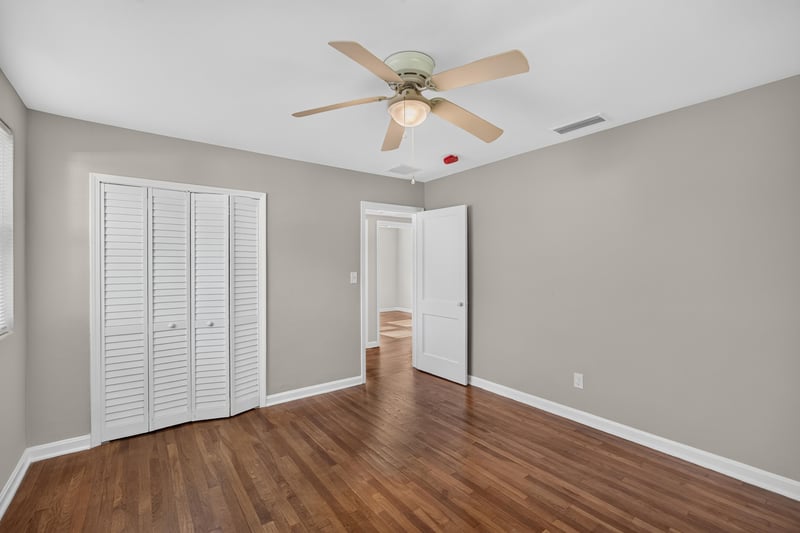 Hallway with closet doors and hardwood floors at 6338 Mercer Cir W, Jacksonville, FL