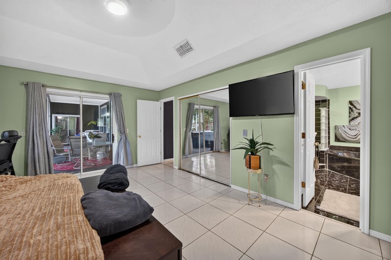 Primary bedroom with tray ceiling and seating area at 1346 Gately Ct, Jacksonville, FL 32225