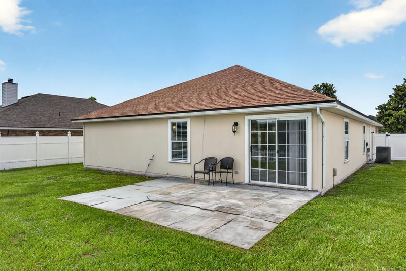 Rear exterior with covered patio and lawn at 490 Hillside Dr, Orange Park, FL 32073