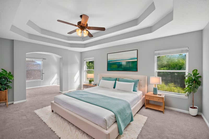 Primary bedroom with tray ceiling, staged bed at 470 Sparrow Branch Cir, Jacksonville, FL 32259