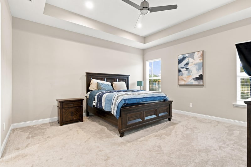 Primary bedroom with tray ceiling and wood furniture at 27 Holly Rdg Wy, St. Augustine, FL