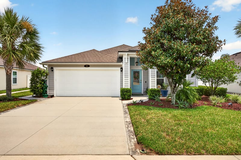 Front exterior with two-car garage and landscaping at 85 Amia Dr, St. Augustine, FL 32086