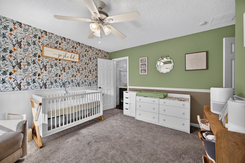Bedroom with floral wallpaper and crib at 2125 Blue Heron Cove Dr, Orange Park, FL 32003