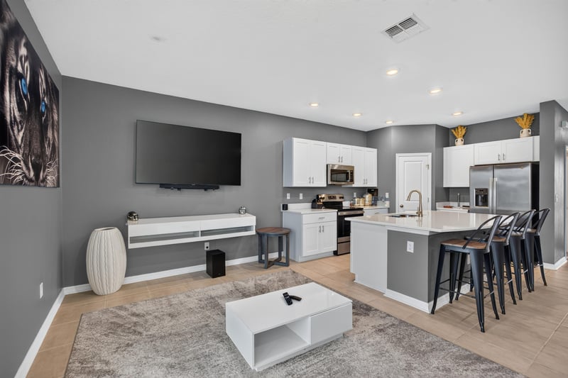 Kitchen with white cabinets and stainless refrigerator open to living room at 339 Anthony Dr, Jacksonville, FL