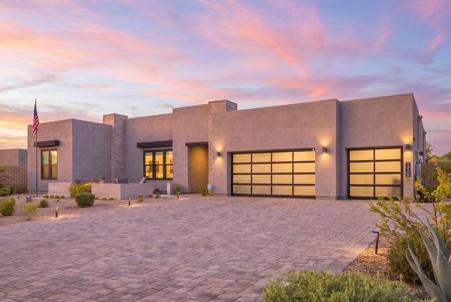Virtual twilight of a modern desert home with glass garage doors