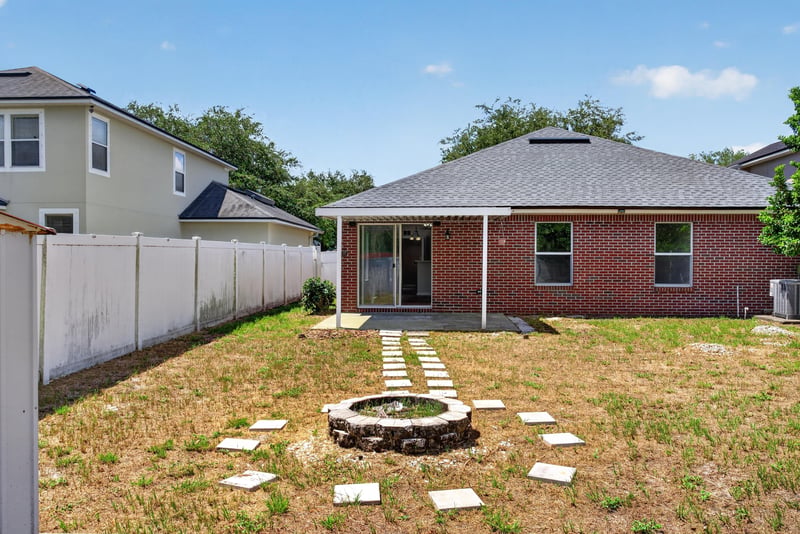 Backyard with fire pit and wood fence at 224 Pine Arbor Cir, St. Augustine, FL 32084