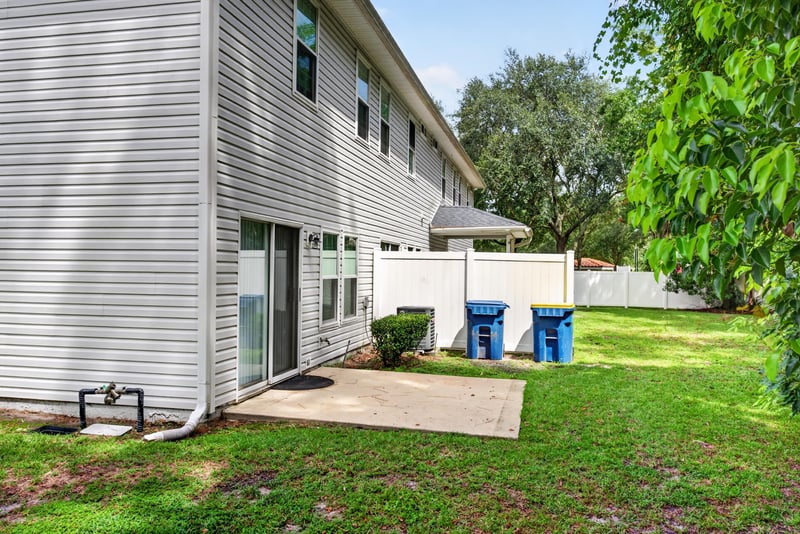 Backyard patio with recycling bins at 12359 Mangrove Forest Ct, Jacksonville, FL 32218