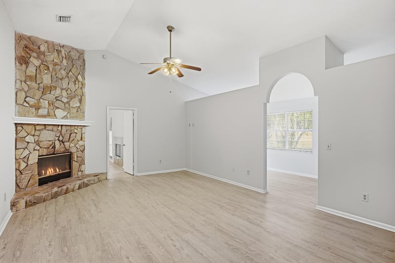 Living room with stone fireplace and vaulted ceiling at 678 5th Ave N, Jacksonville Beach, FL 32250