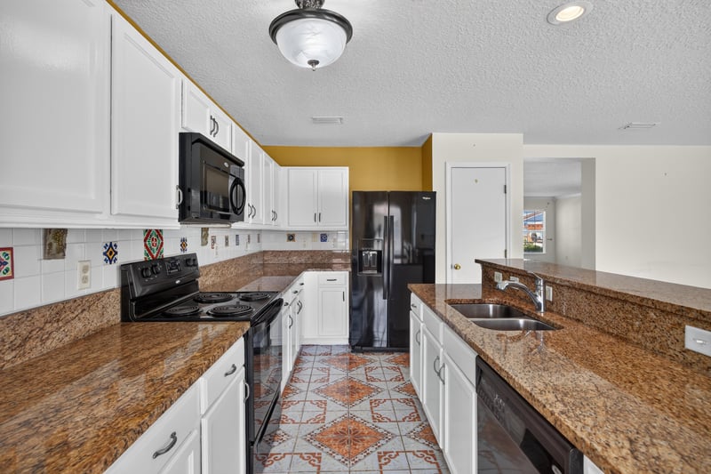 Kitchen sink area with white cabinetry at 2282 Justin Lake Dr, Jacksonville, FL