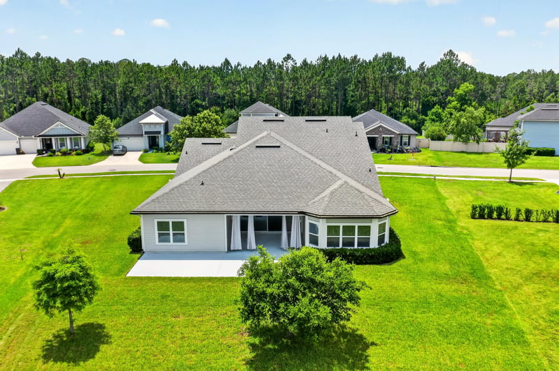 Front exterior angled view with trees and driveway at 53 Lumen Ct, St. Augustine, FL 32095