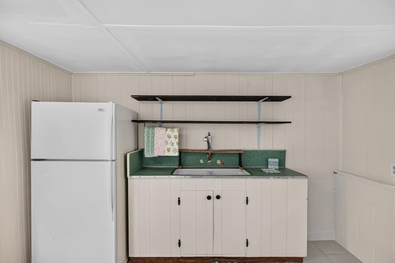 Outbuilding kitchenette with refrigerator and sink at 101 N Lake St, Crescent City, FL