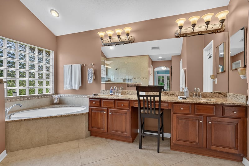 Primary bathroom vanities and tub near windows at 2304 Spring Hill Ct, Orange Park, FL