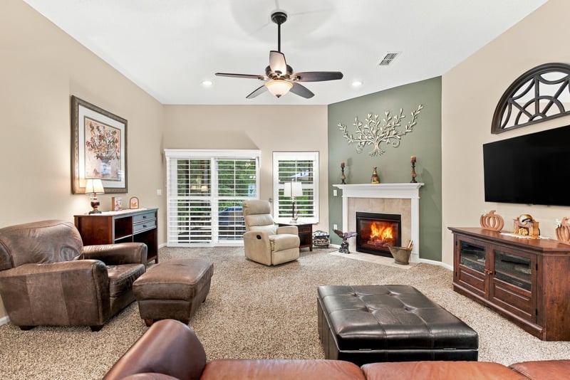 Family room with fireplace and ceiling fan at 10923 Black Diamond Ct, Jacksonville, FL