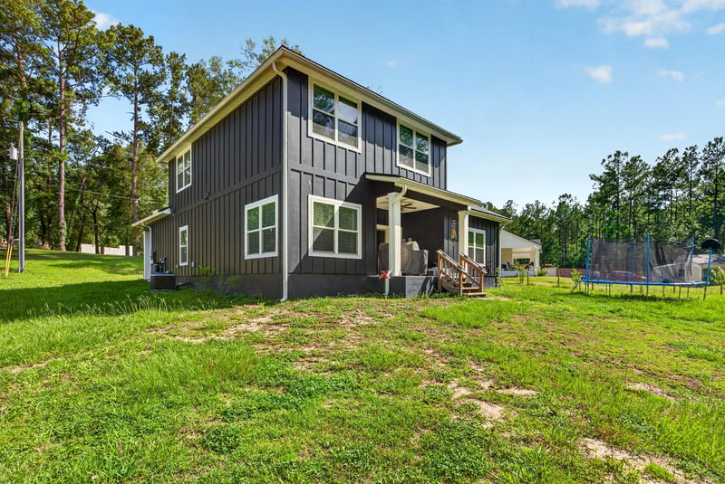 Rear exterior with covered porch and grass yard at 2817 Camel Cir, Middleburg, FL