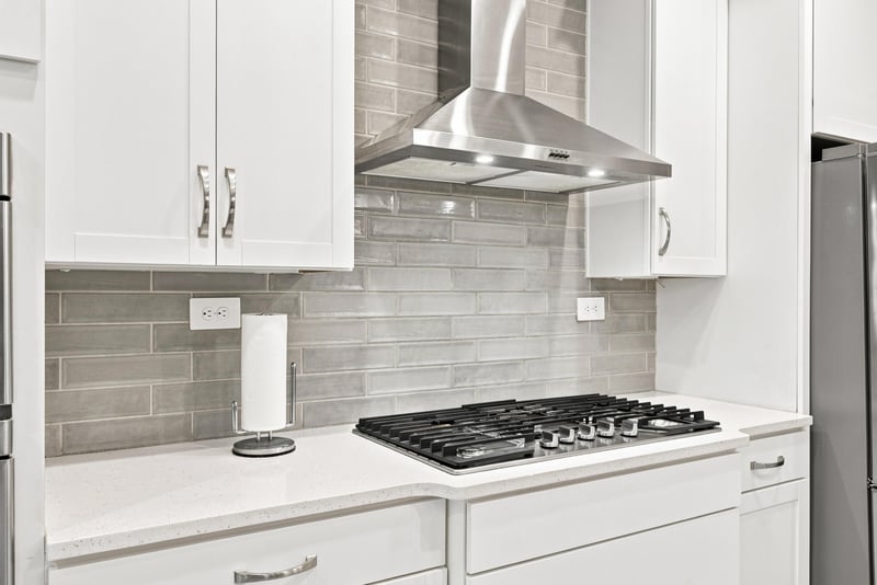 Kitchen cooktop with tile backsplash and range hood at 27 Holly Rdg Wy, St. Augustine, FL