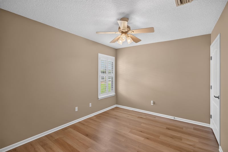 Bedroom with tan walls and ceiling fan at 2131 E Stone Creek Dr, Fleming Island, FL