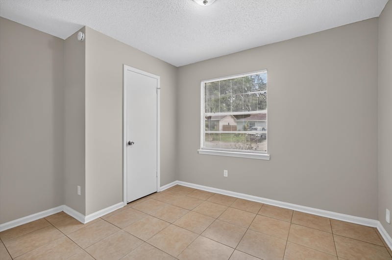 Bedroom with window and tile floor at 1040 Willow Cove Ct E, Jacksonville, FL 32233