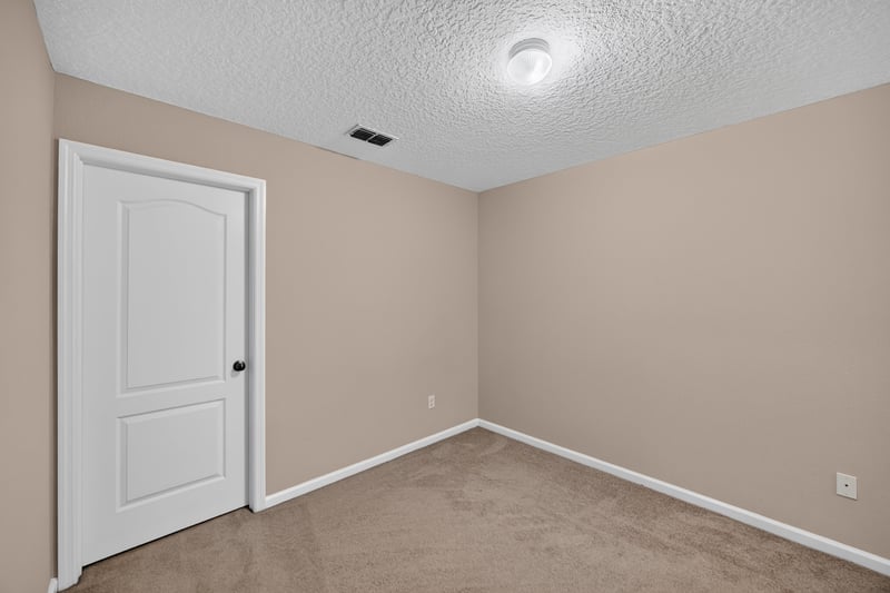 Carpeted bedroom with door at 3762 Hartsfield Forest Cir, Jacksonville, FL 32277