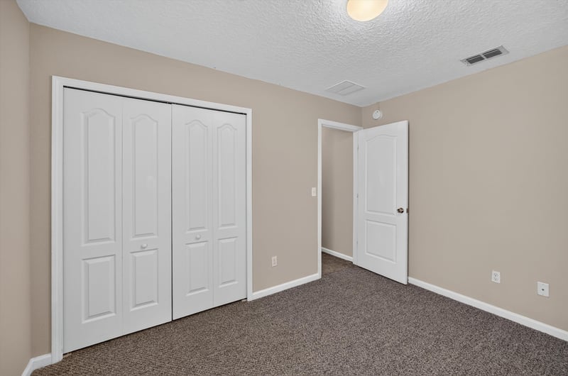 Carpeted bedroom with double closet doors at 469 Glendale Ln, Orange Park, FL
