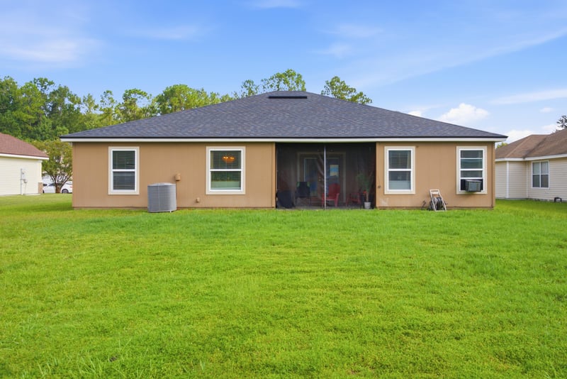Rear exterior with screened porch and lawn at 7392 Timber Falls Ct