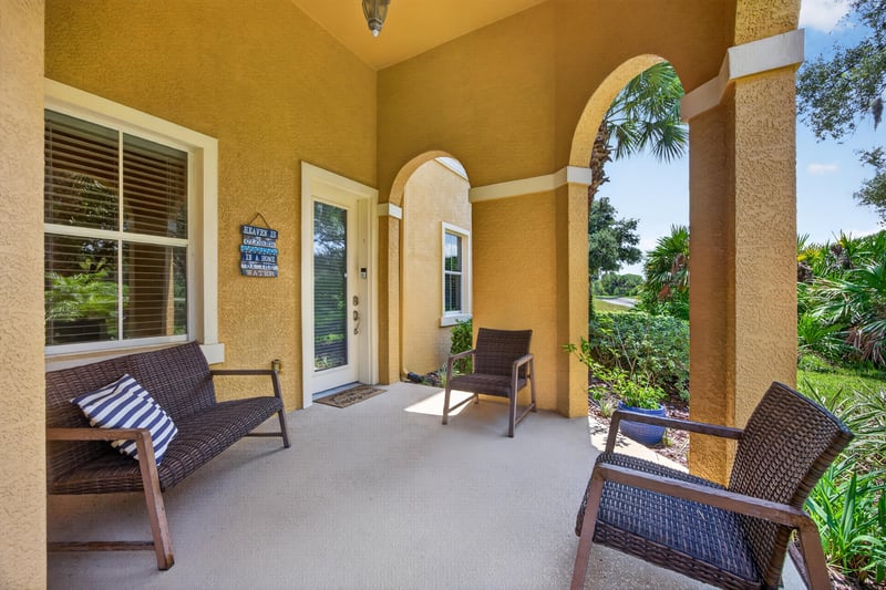 Covered entry porch with wicker furniture and arched columns at 140 Ave De La Mer, Palm Coast, FL 32137