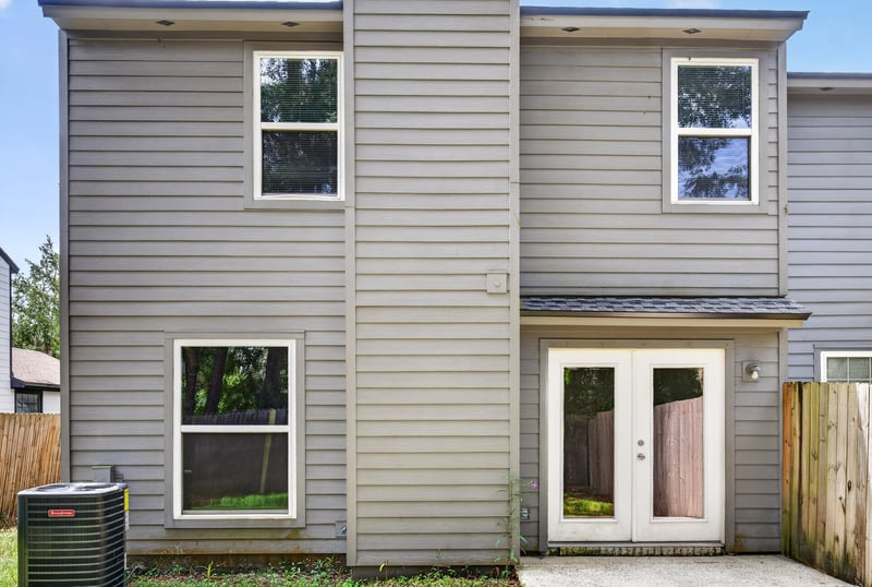 Side exterior with two-story siding and AC unit at 4427 Millstone Ct, Jacksonville, FL