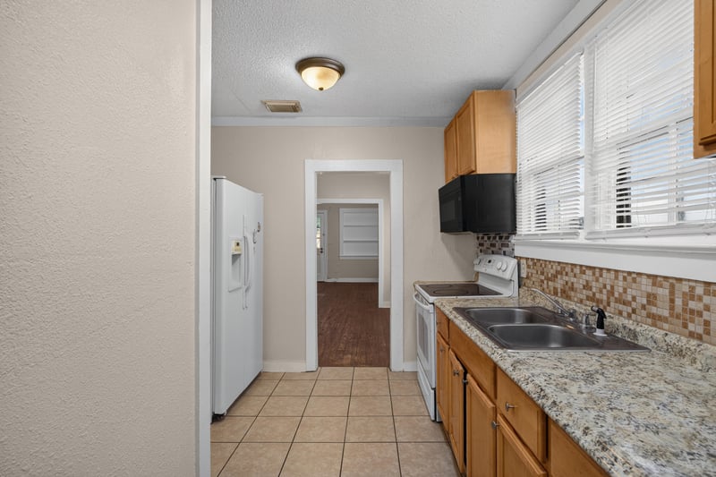 Kitchen with granite counter, sink and refrigerator at 1473 State St W, Jacksonville, FL 32209