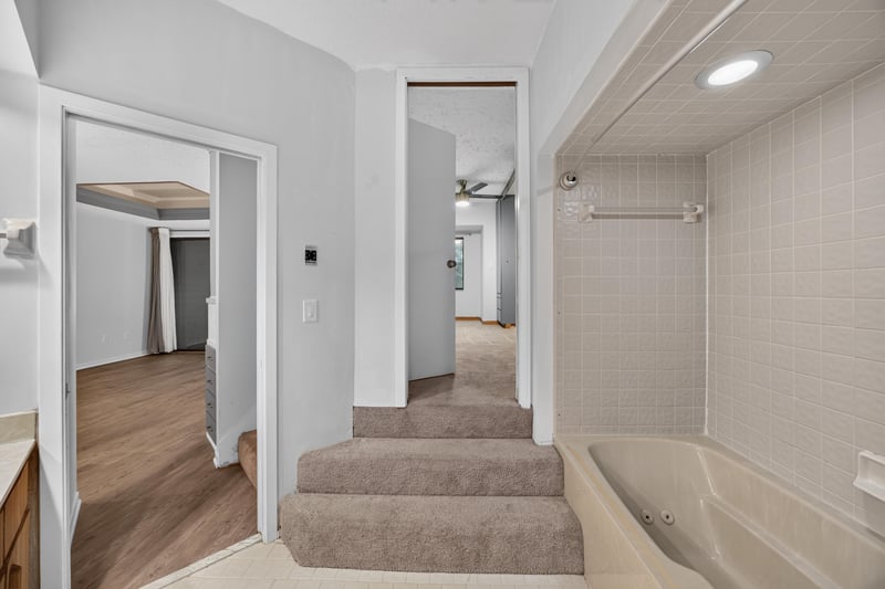 Hallway with stairs down and laundry closet at 2910 Ravines Rd, Middleburg, FL 32068