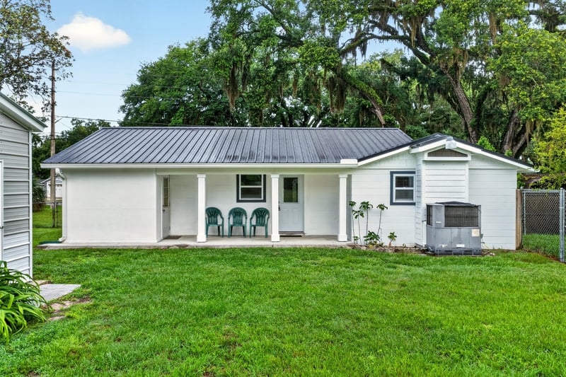 Backyard view of the home with metal roof and carport at 1619 Hammond Blvd, Jacksonville, FL