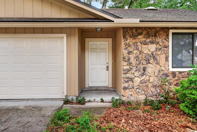 Garage door and stone-accented entry at 1445 Classic Oak Rd W, Jacksonville, FL
