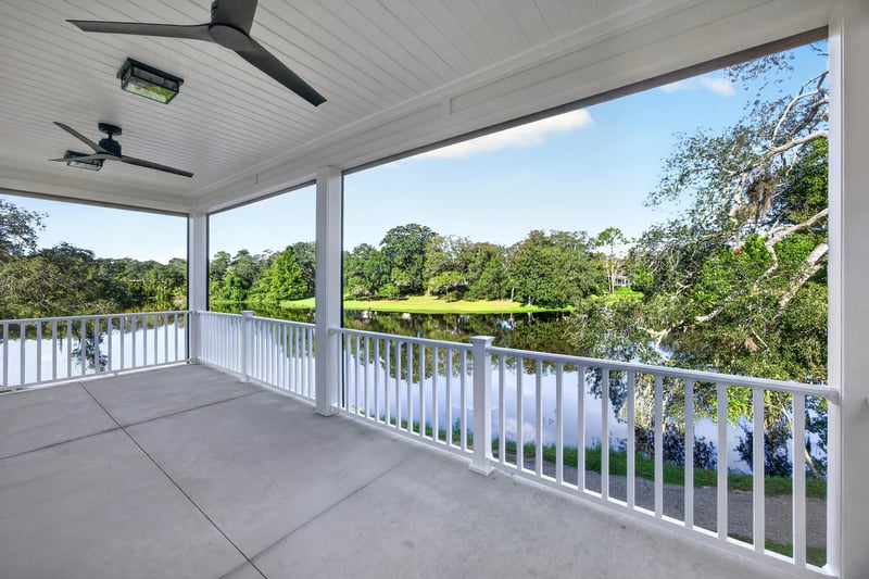 Covered back porch with railing overlooking pond at 175 Alava Ct
