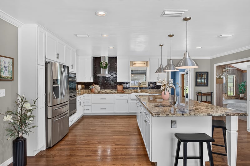 Kitchen with white cabinets, granite island, and stainless refrigerator at 5843 Ovella Rd, Jacksonville, FL 32244