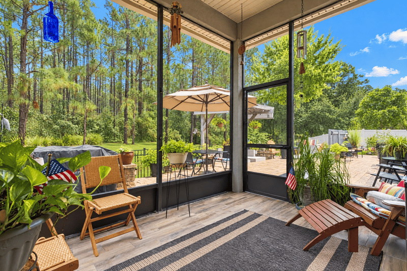 Screened porch with seating and american flag at 10923 Black Diamond Ct, Jacksonville, FL