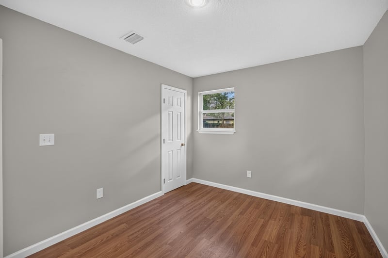 Hallway with wood floor and doorway at 7015 Miss Muffet Ln N, Jacksonville, FL 32210