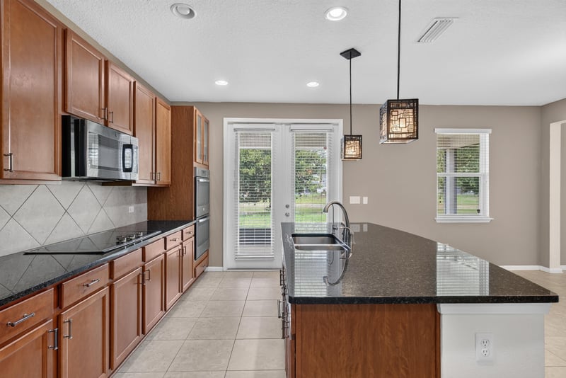 Kitchen view with granite island and French doors at 263 Gilmore Ln, Orange Park, FL 32065