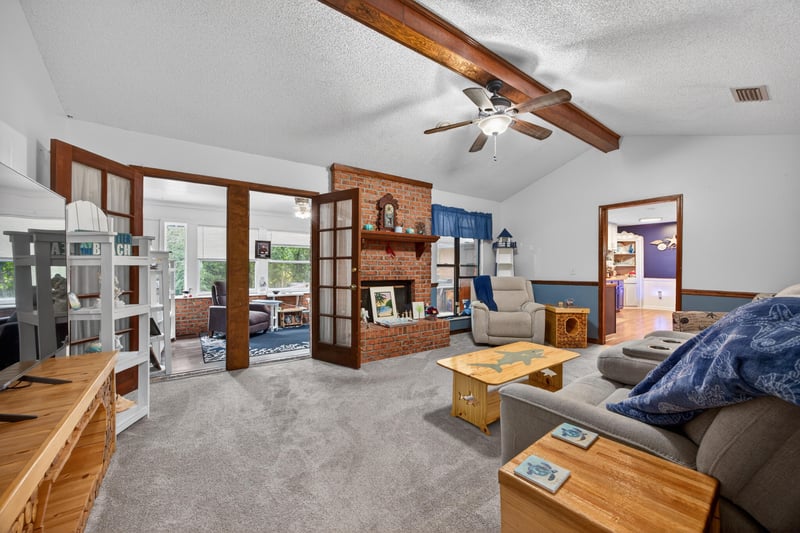 Living room with wood beam ceiling and French doors at 981 Marble Ridge Dr, Orange Park, FL 32065