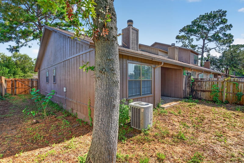 Side yard with chimney and trees at 8010 International Village Dr, Jacksonville, FL 32277