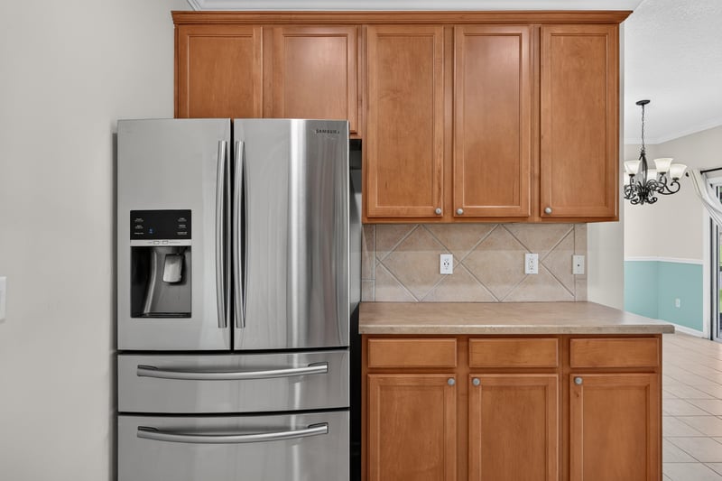 Kitchen with stainless refrigerator and wood cabinets at 1493 Greyfield Dr, St. Augustine, FL 32092