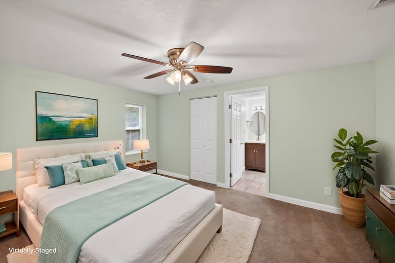 Staged primary bedroom with teal bedding and ensuite access at 1619 Hammond Blvd, Jacksonville, FL