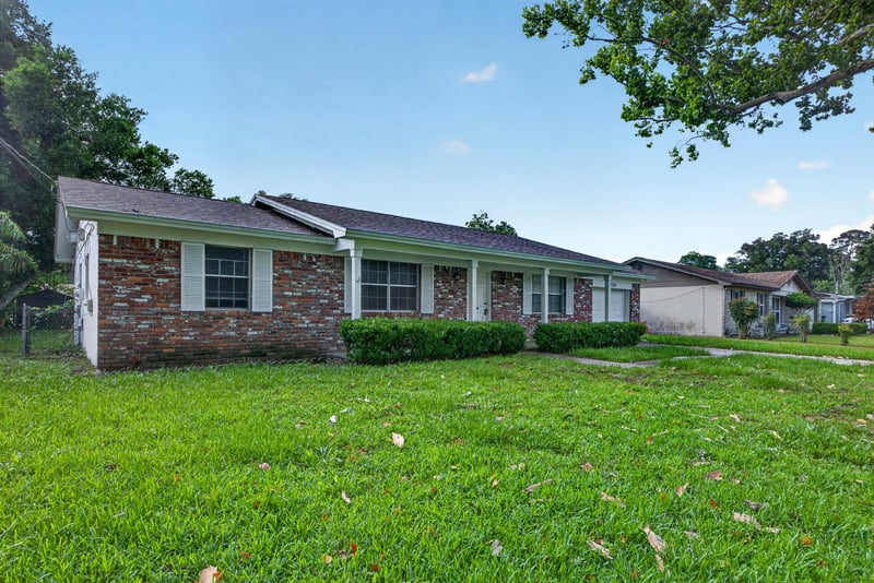 Front exterior view with driveway and mature shade trees at 12351 Condor Dr