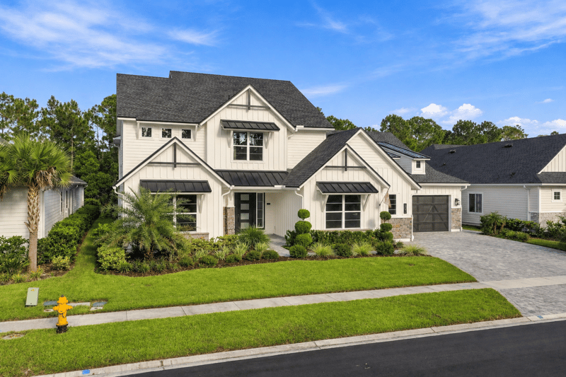 Front exterior with palm trees and paver driveway at 907 Seagrove Dr, Ponte Vedra Beach, FL 32081