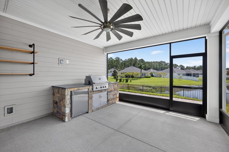 Screened lanai with outdoor kitchen and pond view at 855 Flach Dr, St. Johns, FL