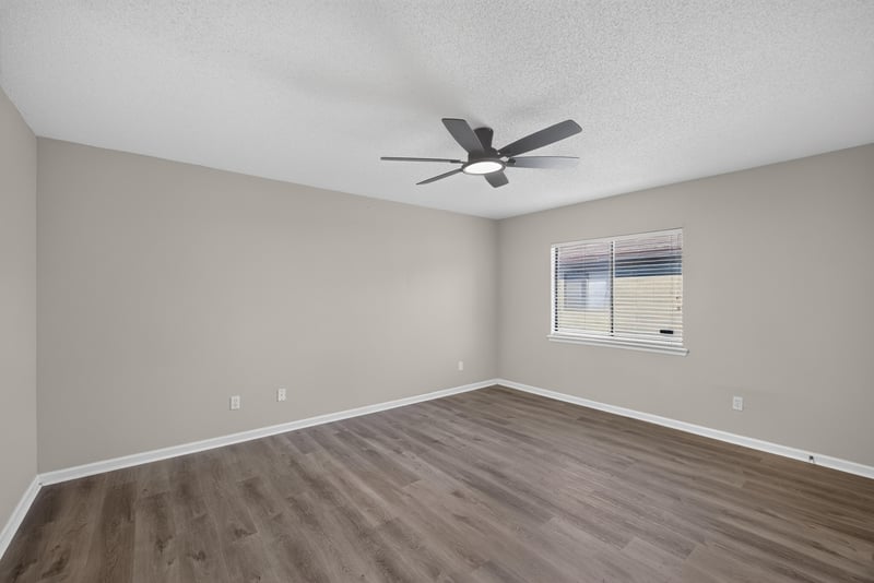 Empty bedroom with ceiling fan and window at 7723 Playschool Ln, Jacksonville, FL